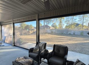 Interior view of covered patio with motorized retractable screens providing shade, airflow, and outdoor visibility